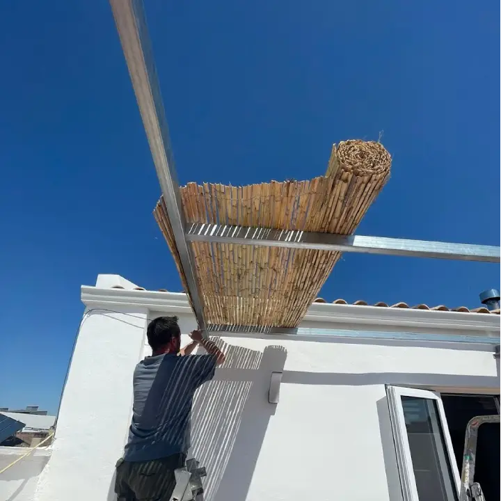 Técnico montando un toldo de madera con estructura metálica
