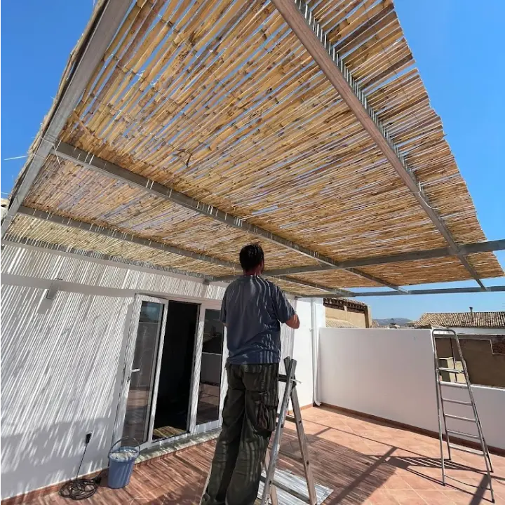 Técnico montando un toldo de madera con estructura metálica
